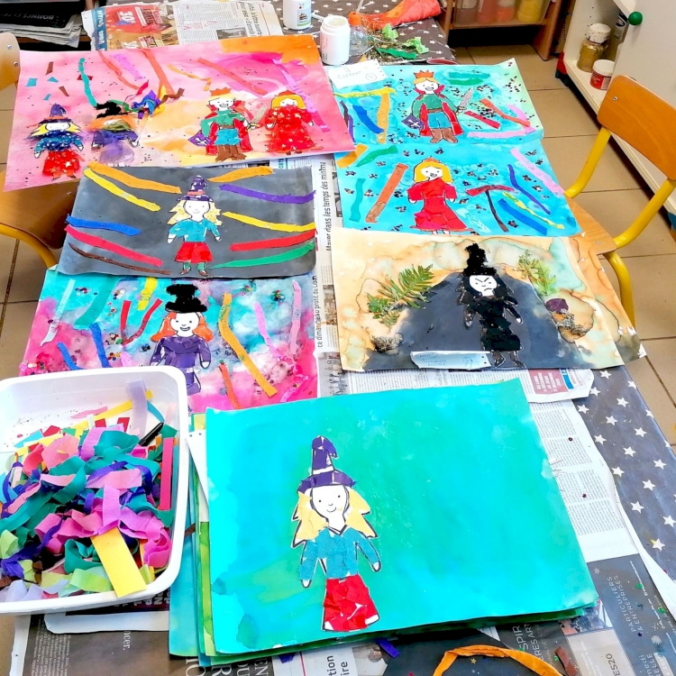 Sur la table de l'atelier de la classe, les dessin sont exposés après avoir été mis en couleurs.