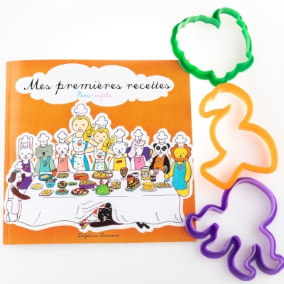 Kit du petit cuisto Mes premières recettes de Delphine Dumont  Editions Plumes et Confettis Le livre de recette de cuisine illustré est accompagné de 3 emporte-pièces à sablés vert, orange et violet.